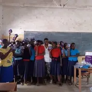 Anne S. from Tanzania distributes menstrual pads to girls in her local community.